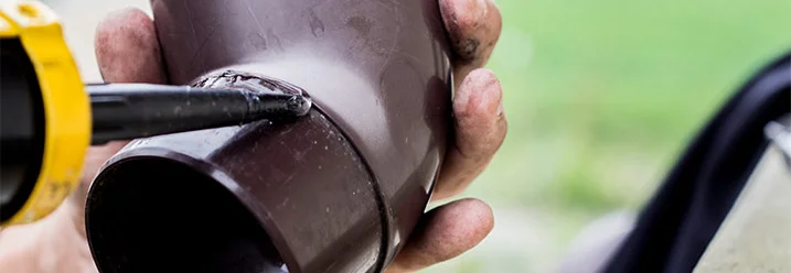 Hand verklebt Fallrohr mit Dichtmittel